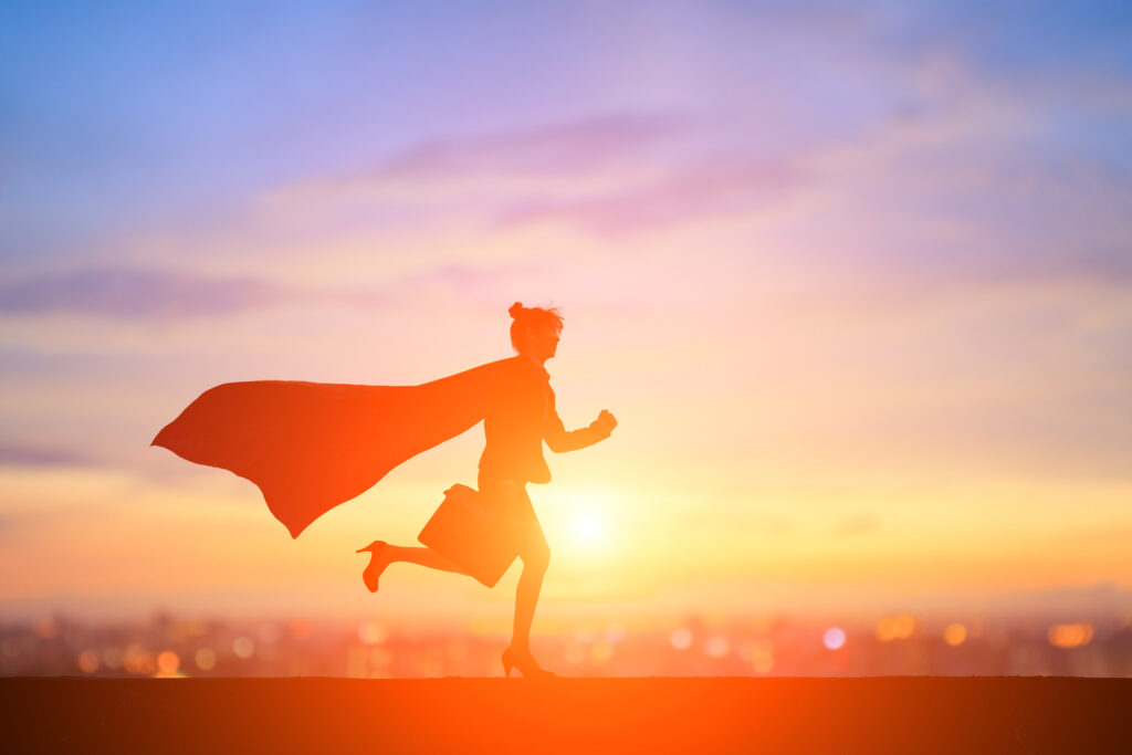 Businesswoman running with a super hero cape