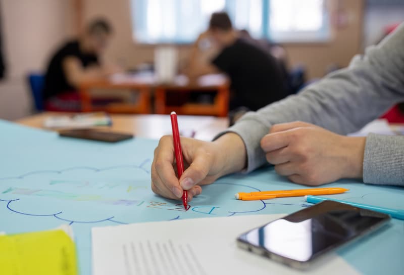 a person writing on paper during their workplace learning development session